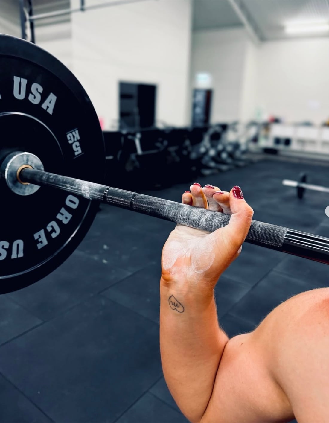 A lifter chalked up, gripping the barbell.